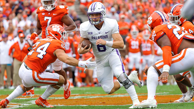 Furman+QB+Tyler+Huff+squeezes+past+Clemson+safety+Tyler+Venables.