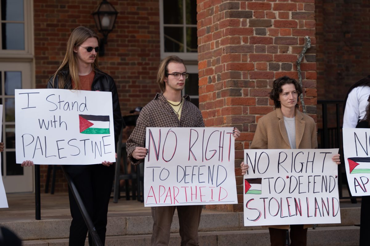 Furman community members hold signs at a recent vigil for lost lives in Gaza. Will Wand/The Paladin