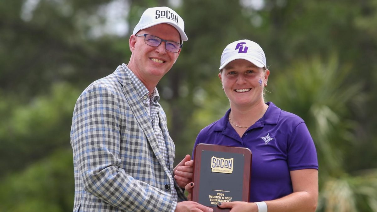 Southern Conference Commissioner, Michael Cross hands the 2024 Womens Golf Tournament Championship plaque to Furman Senior Anna Morgan. With the win, Morgan claimed her second SoCon Individual Title.